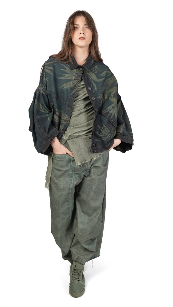Person trägt oversized grüne Militärjacke mit abgewetzter Optik und weite Cargo-Pantalons, stilvoll kombiniert.
