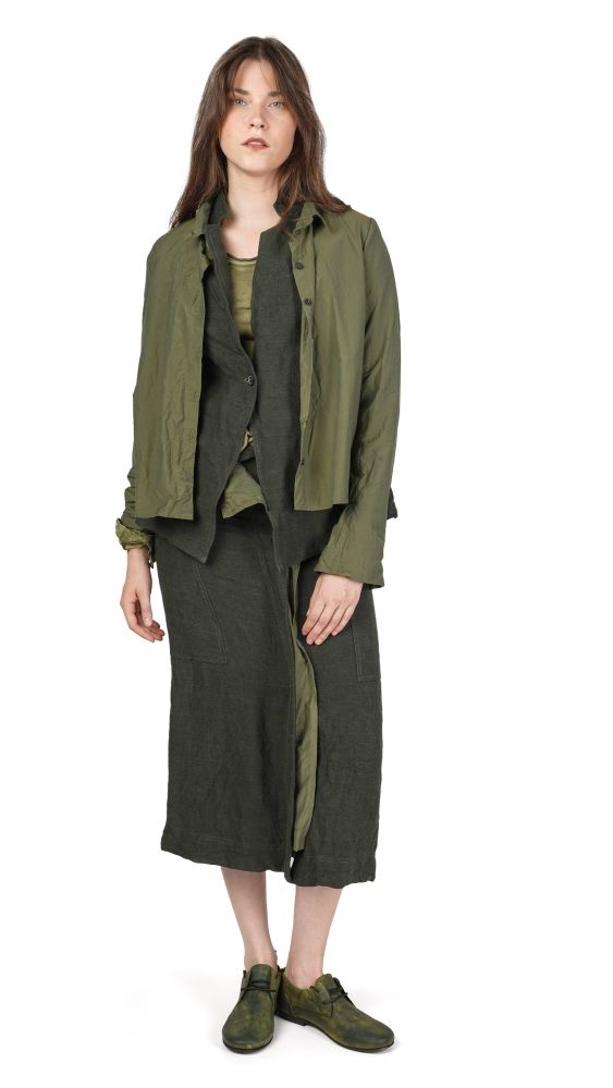 Frau trägt olivgrünen oversized Blazer mit langem, dunklem Wickelrock und grünen Schuhen.