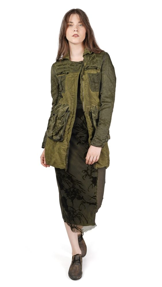 Frau trägt olivgrünen oversized Jackenlook mit zerrissener Hose und flachen Schuhen.