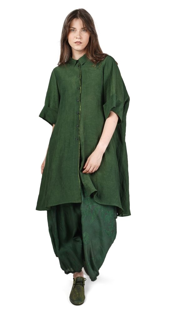 Frau trägt grünes langes Shirt mit weitem Schnitt und oversized Hosen, schlichtes Outfit.