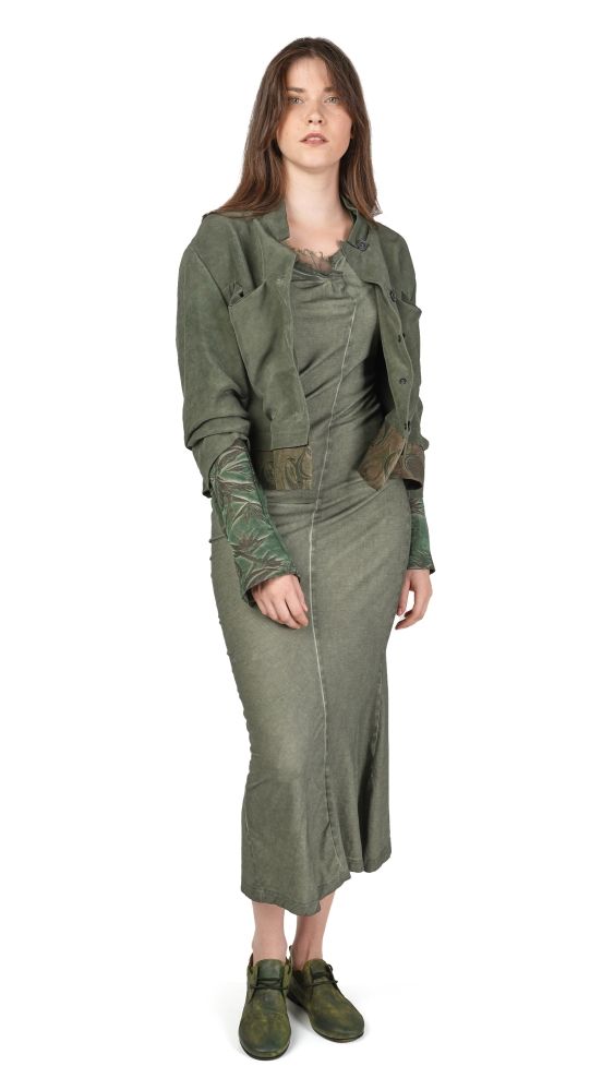 Frau trägt langes, grünliches Kleid mit oversized Jacke und Accessoires, steampunk-inspiriert.