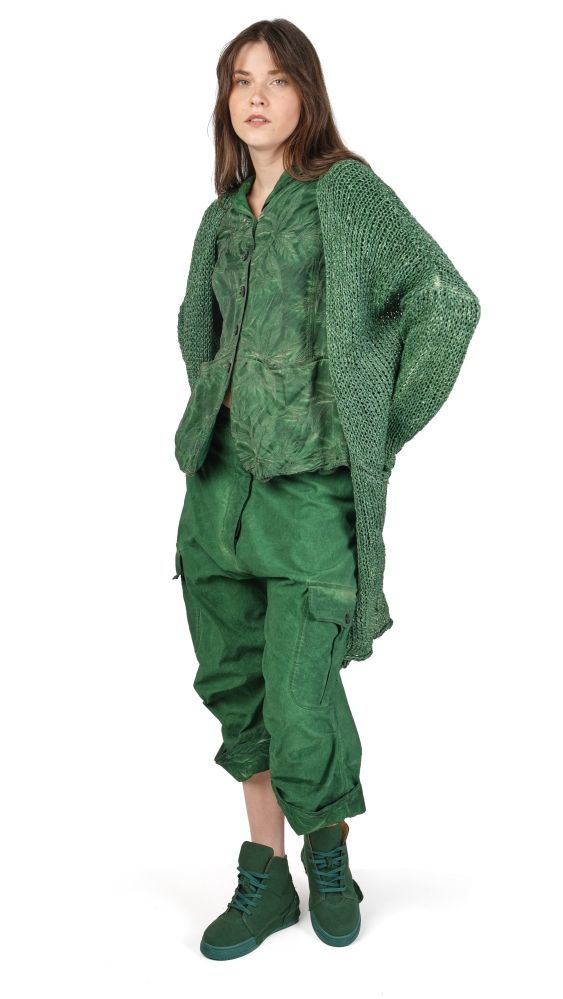 Person trägt oversized grünes Ensemble mit Strickweste, weiten Hosen und Blockabsätzen.