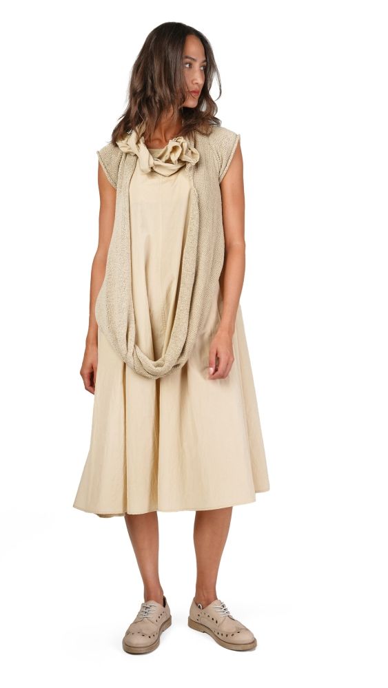 Frau trägt cremefarbenes, langes Kleid mit knielangem Rock und knöpfartigem Schal-Akzent, beige Sneakers.