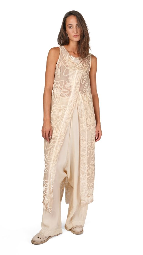 Eleganter beige Schleierkleid mit floralem Muster, lang und fließend, mit Sandaletten getragen.