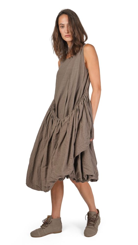 Frau trägt lockeres, langes graues Wickelkleid mit schlanken Schuhen, lässiger Stil.