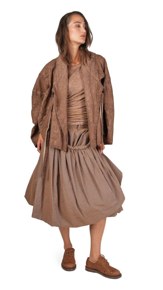 Frau trägt braunen oversized-Pullover mit weitem Rock und braunen Schuhen, lässiger Look.