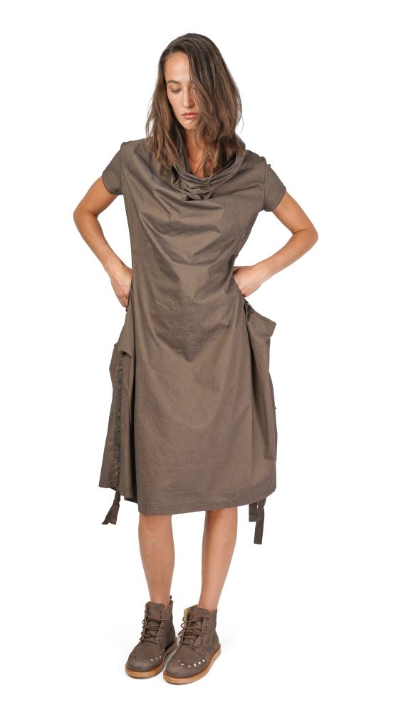 Frau trägt oversized braunes Wickelkleid mit Handtaschen-Ausschnitt und robusten Stiefeln.