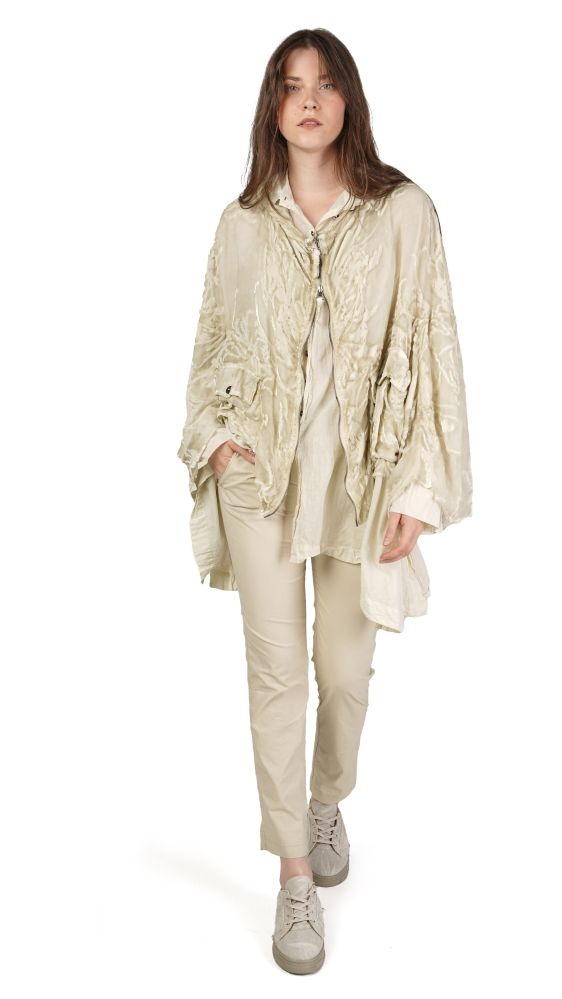 Frau trägt oversized beige Bluse mit weitem Rock und bequemen Sneakern.