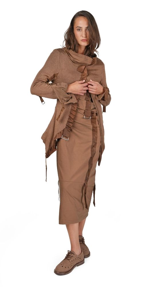 Frau trägt bohemien-inspirierten, braunen Wickelrock mit langem Schal und Stiefeletten, lässig posierend.