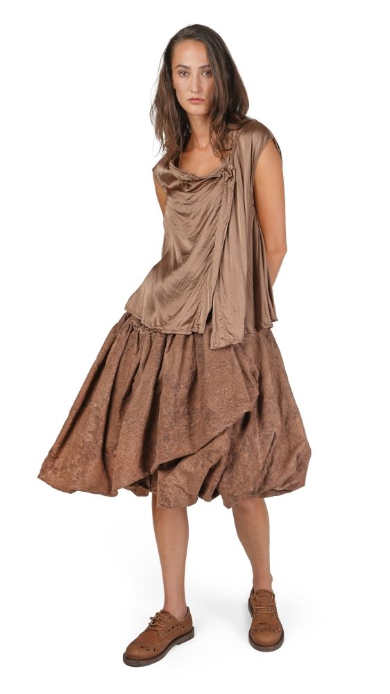 Frau trägt bohemisches, langes Kleid mit weitem Rock und braunen Stiefeletten.