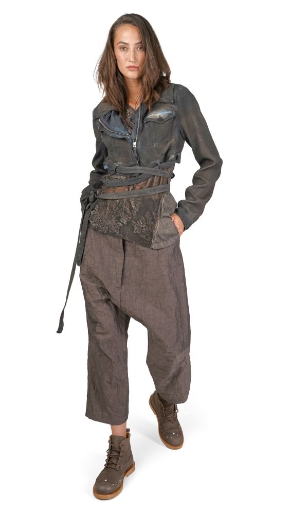 Stylische Person in oversized Jacke, weiten Hosen und robusten Stiefeln mit Gürtel und Tasche.